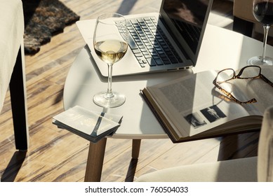 Modern Wine Bar Cafe With Computer, Book And Glasses Of Alcohol On Table Side Angle View.