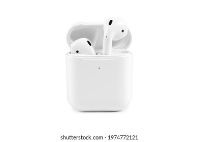 Modern wireless earbuds headphones lying in a charging case isolated on white background. 