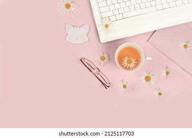 Modern Woman's Desktop, Home Office. Computer, A Cup Of Chamomile Tea And Spring Flowers On A Pastel Table. Minimal Business Concept, Hello Summer, Home Comfort, Top View, Flat Lay, Space For Text.