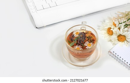 Modern Woman's Desktop, Home Office. Computer, A Cup Of Chamomile Tea And Spring Flowers On A Pastel Table. Minimal Business Concept, Hello Summer, Home Comfort, Top View, Flat Lay, Space For Text.