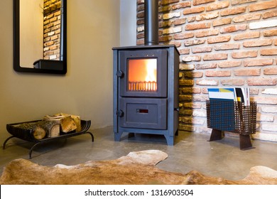 Modern Wood Burning Stove Inside Cozy Living Room With Rustic Brick Walls And Bear Skin On The Floor.