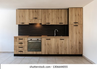 Modern Wood Kitchen In The Apartment With White Walls. Warm And Copy Space