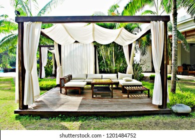 Modern wooden beach pergola  with withe curtain ,table, in front of the beach 