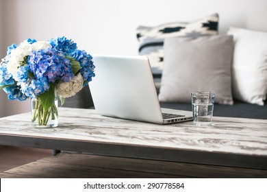 Modern Wooden Coffee Table, Laptop And Cozy Sofa With Pillows. Living Room Interior And Home Decor Concept