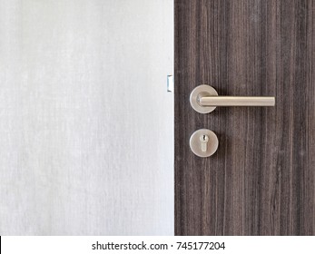 Modern Wooden Door With Metal Door Handle Over The White Wall.