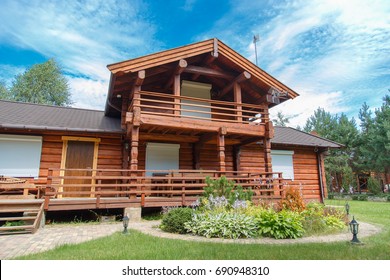 A Modern Wooden House Made Of Logs. View From Outside In Summer