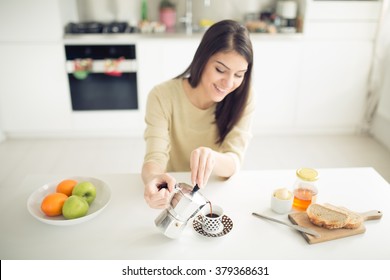 Modern working woman lifestyle-drinking moka coffee in the morning in the kitchen,starting your day.Positive energy and emotion.Productivity,happiness,enjoyment,determination.Morning ritual