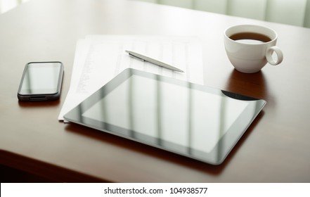Modern workplace with digital tablet computer and mobile phone, cup of tea, pen and paper with numbers.