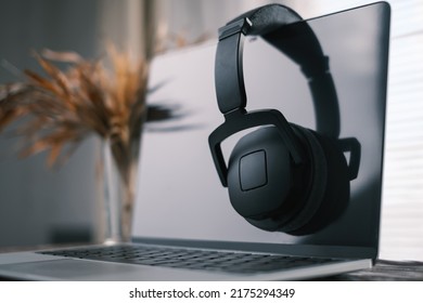 Modern workplace of a freelancer, blogger or musician. The headphones are hanging on the laptop. - Shutterstock ID 2175294349