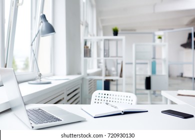 Modern Workplace With Laptop And Notepad, Interior Of Spacious Open Plan Office On Background, No People