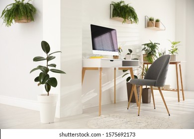 Modern workplace in room decorated with green potted plants. Home design - Shutterstock ID 1575692173