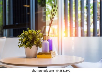 Modern Workplace With Tree Pot And Reed Freshener On Wooden Table