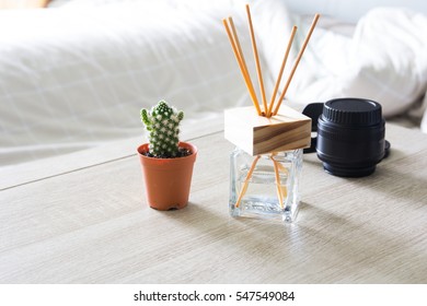 Modern Workplace With Tree Pot And Reed Freshener On Wooden Table