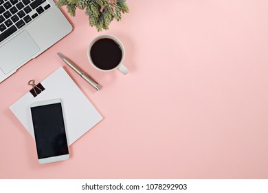 Modern workspace with coffee cup, smartphone and laptop copy space on pink color background. Top view. Flat lay style.