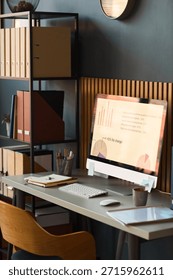 Modern workspace featuring desktop computer displaying business analytics charts and graphs, organized desk with office supplies, shelving unit with folders and binders in background