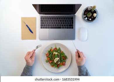 Modern Workspace, Male Having Lunch Break And Eats Healthy Food Served In Plate, Fish With Veggies And Salad At The Computer, Top Overhead View, Flat Lay Style 