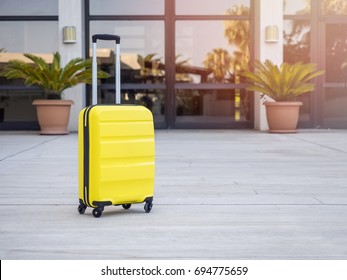 Modern Yellow cabin suitcase in the waiting area in airport