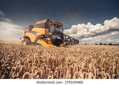 Modern Yellow Combine Harvesting Wheat During Summer In Czech Republic, South Moravia, Before The Rain. Agricultural Machine Harvester Working In The Field Using GPS For Precision Farming.