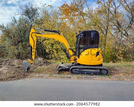 Modern yellow JCB digger or excavator performs excavation work outdoors