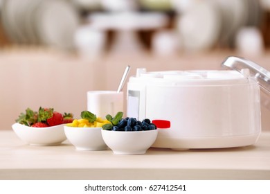 Modern yogurt maker and ingredients on kitchen table - Shutterstock ID 627412541