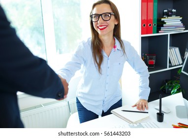 Modern Young Business Woman With Arm Extended To Handshake