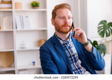 Modern Young Businessman Having Phone Conversation While Working In An Office, Serious And Pensive