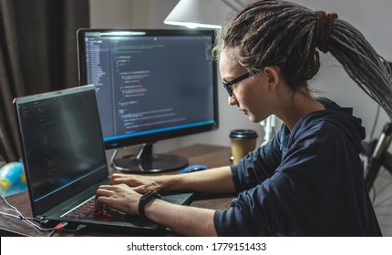 Modern young female programmer is writing program code on a laptop at home. Remote work in the IT profession. The concept of software development. - Shutterstock ID 1779151433
