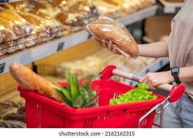 Modern young woman with long hair choosing bread in grocery store in morning, copy space - Powered by Shutterstock
