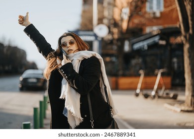 Modern young woman multitasking in the city, hailing a cab with one hand while making a business call on the phone with the other. - Powered by Shutterstock