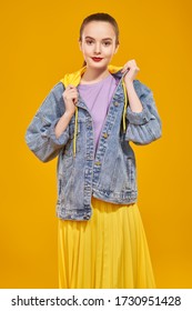 Modern youth look. Beautiful young girl in bright summer clothes posing on a yellow background. Beauty, fashion.