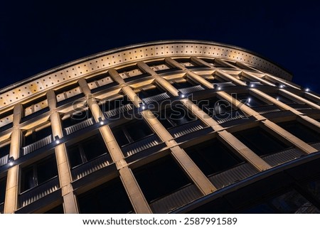 A modernly designed building at night, featuring warm light and symmetrical design in an elegant, contemporary style