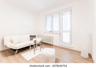 Modernly Furnished Living Room In Small City Apartment. Simplicity And Airiness Are Main Features Of The Room,which Is Dominated By Sofa With Coffee Table,there Are Also Small Decorative Accessories.