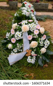 Modest Flower Arrangements And Wreaths On White Coffin In Small Lutheran Churchyard. Typical Funeral Tradition. Raasiku Village, Estonia, Europe.