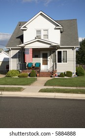 A Modest House With An American Flag, In A Small Town.