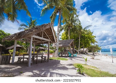 Modest huts with nipa roofs for rent to families looking to picnic by the beach. At Dumaluan Beach in Panglao Island, Bohol, Philippines. - Powered by Shutterstock