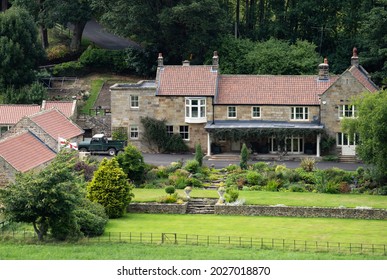 A Modest Sized  English Country House With Tiled Roof And Pretty Garden. They Have A St George Cross Flag Flying.
North Yorkshire, England: August 18th 2021