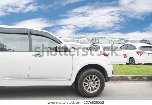 Modified\
image of  fictional  car. white car parked outdoor parking lot with\
white cloud and blue sky copy space background. Transportation\
automotive photography and traveling concept.\
\