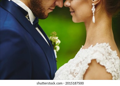 Modish Groom Kissing Gorgeous Bride During The Wedding Ceremony. A Loving Couple, A Woman In A Wedding Dress And Handsome Man In A Stylish Blue Suit