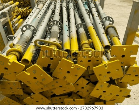 modular metal scaffold components painted in yellow
