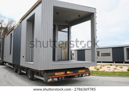 Modular prefabricated house module moving on a semi trailer, emphasizing modern construction, efficient logistics, and sustainable housing