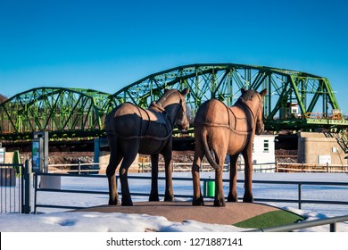 Mohawk, NY/USA-March 24, 2018:
Horse Statues At The Mohawk Valley Welcome Center Recreation Park With A Bridge Over The River On The Background During Sunrise. Located On The Westbound Of I-90