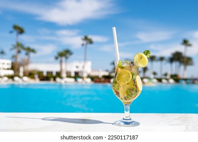 Mohito fresh cold cocktail on the wooden table with eco paper straw in the all inclusive hotel near the swimming pool - Powered by Shutterstock