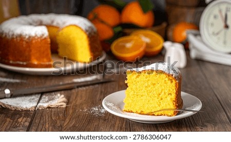 Moist orange pound cake slice on a plate with powdered sugar topped bundt cake ready to enjoy