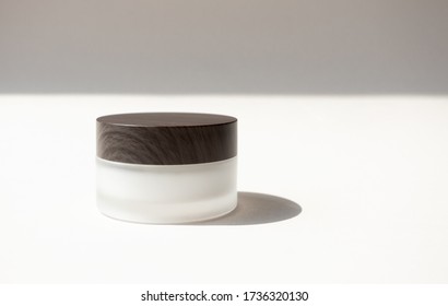 Moisturizer Cream Or Body Lotion In Frosted Glass Jar With Wooden Cup And Copy Space On Beige Background With Shadow In Top. Mockup Skincare Beauty Product Front View