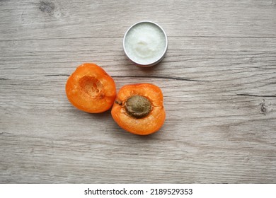 Moisturizer cream in open plastic jar and apricots on wooden background.  Mockup with copy space. Cream bottle for branding and label, top view. Vitamin intense seed of apricot kernel. - Shutterstock ID 2189529353