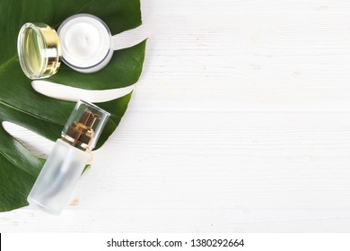 Moisturizing care skincare face cream for healing complicated troubled skin type in an open jar with visible texture. Copy space, close up, background, flat lay, top view. Monstera leaf decoration.