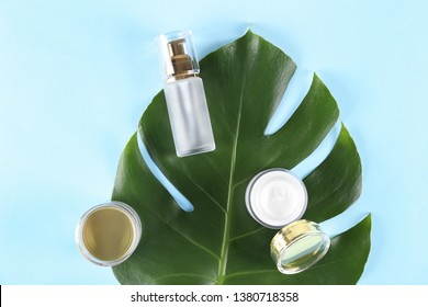 Moisturizing care skincare face cream for healing complicated troubled skin type in an open jar with visible texture. Copy space, close up, background, flat lay, top view. Monstera leaf decoration.
