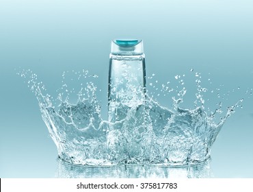 Moisturizing shampoo for dry hair. The bottle of clear liquid stays on the turquoise water background with big splash