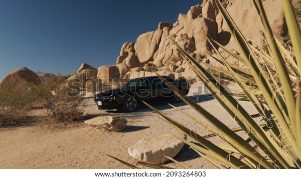 Mojave Desert, USA - September 2,2021:American\
muscle car Dodge Challenger in the sand desert. It is the name of\
three different generations of automobiles produced by automobile\
manufacturer Dodge