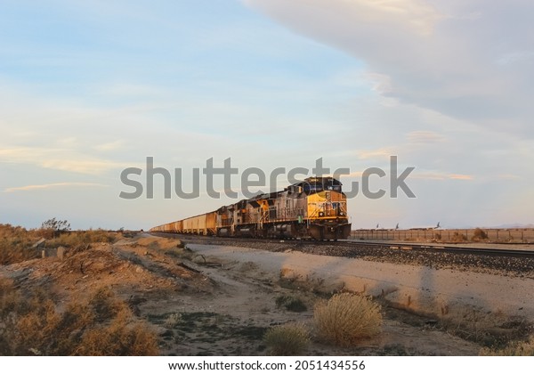 MOJAVE, UNITED STATES - Feb\
10, 2018: Scenic view of long freight train in California desert at\
sunset